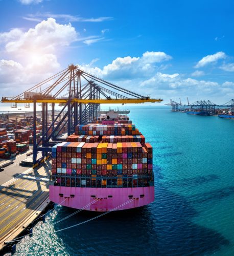 Aerial view of cargo ship and cargo container in harbor.